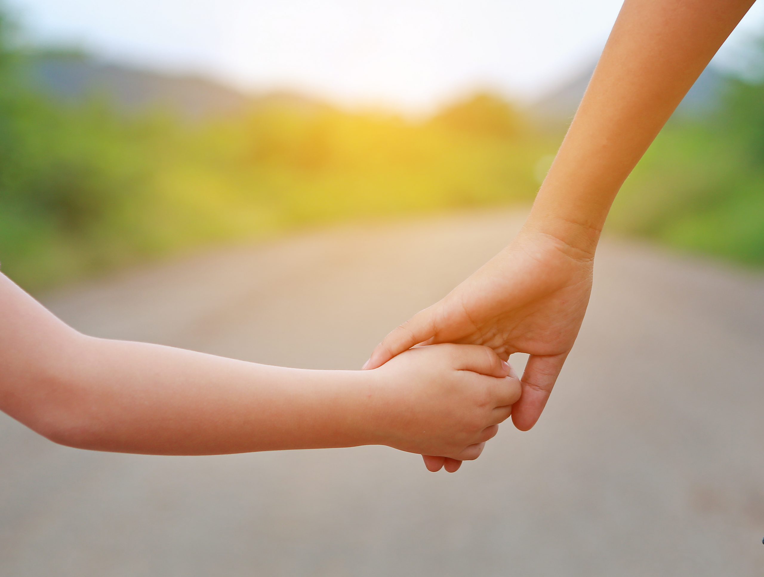 Close up of Sister hold hands with small children walking on the road. bipolaire stoornis depressie